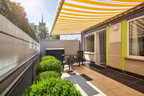 a patio with chairs and a table on a balcony at Casa Pinos City in Friedrichshafen