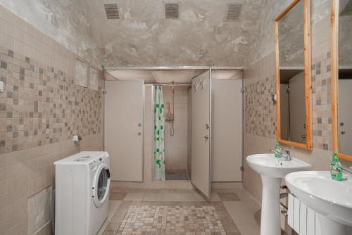 a bathroom with a sink and a washing machine at Hostel Manjari in Sochi