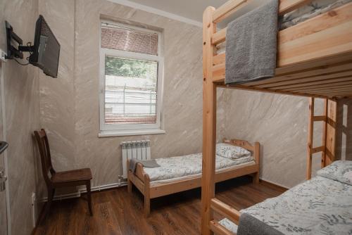 a bedroom with two bunk beds and a window at Hostel Manjari in Sochi