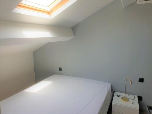 une chambre avec un lit blanc et une lucarne dans l'établissement DUPLEX BALCON CENTRE MER 508, à Nice