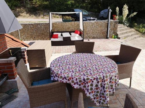 a patio with a table and chairs and a couch at Ezüsthíd Apartman in Balatongyörök