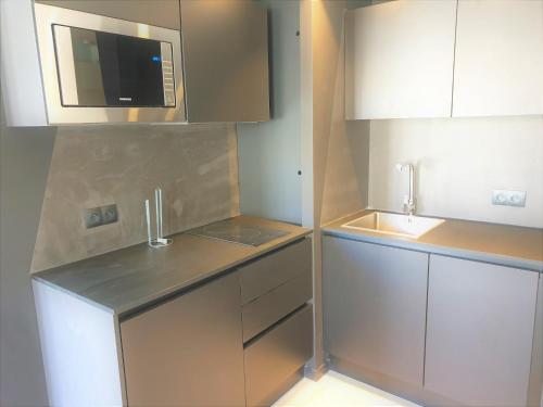 une petite cuisine avec un évier et un micro-ondes dans l'établissement DUPLEX BALCON CENTRE MER 508, à Nice