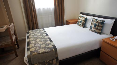 a hotel room with a bed and a window at Abbey Court Hotel - Hyde Park in London
