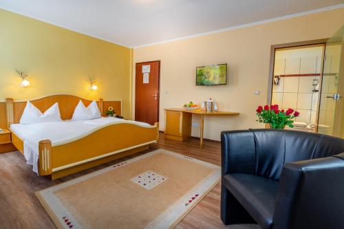 a bedroom with a bed and a chair and a table at Goldener Pfropfenzieher in Oberwesel