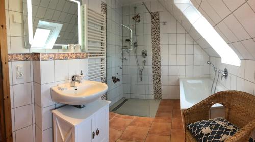 a bathroom with a sink and a shower and a tub at Zingst Haus Hugo in Zingst