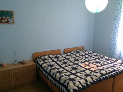 a bedroom with a bed with a black and white quilt at Winery & Brewery - Family Guesthouse "Villa Rbona" in Khashuri