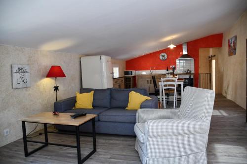 un salon avec un canapé bleu et deux chaises dans l'établissement Le pigeonnier, à Malaucène