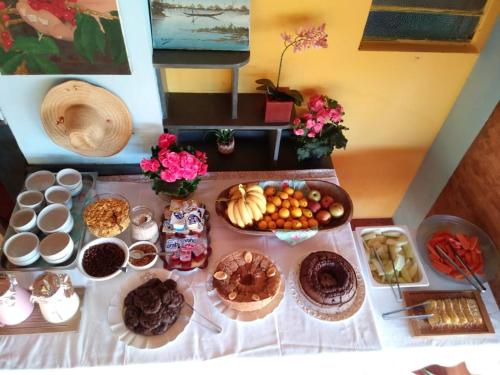 a table topped with lots of different types of food at Fazenda Paisagem Chalés in Serra Negra