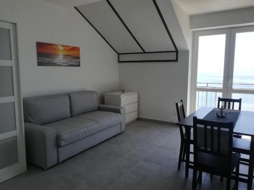 uma sala de estar com um sofá e uma mesa em Villa Adagio Apartments em Sumartin