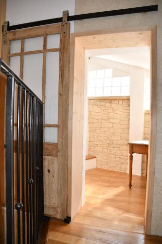 una puerta abierta en una habitación con una pared de ladrillo en Le pigeonnier, en Malaucène