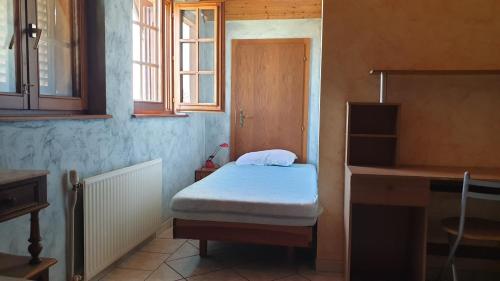 a small room with a small bed and a window at location à la campagne aux portes de Mulhouse in Sausheim