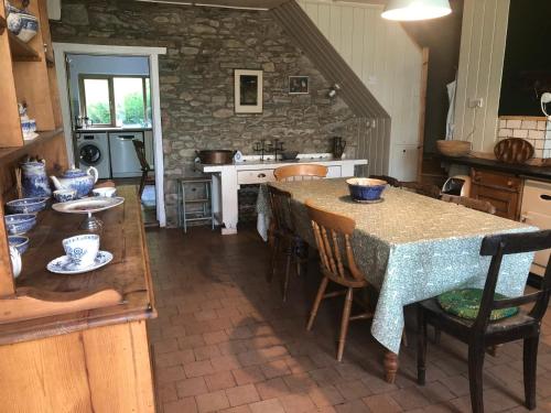 a kitchen with a table and some chairs and a counter at Gernos Farmhouse in Llandysul