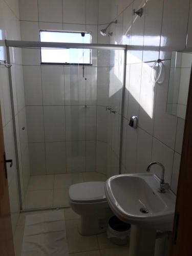 a bathroom with a shower and a toilet and a sink at BRAVO CITY HOTEL CAMPO VERDE in Campo Verde