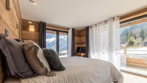 una camera con un letto e una grande finestra di chalet des grands bois a Les Houches