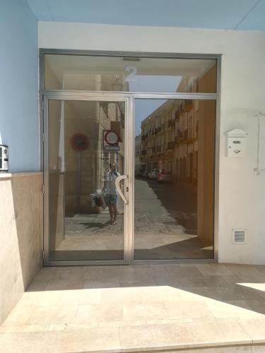 a glass door of a building with a person reflected in it at Apartamento L&G Centro in Ayamonte