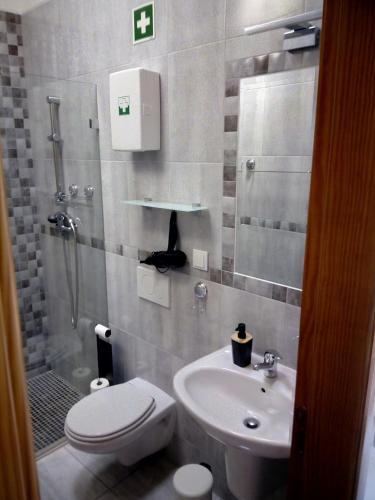 a bathroom with a sink and a toilet and a shower at O Nosso Lar in Lagos
