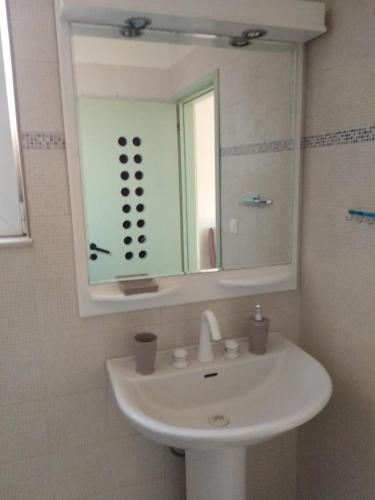 a bathroom with a white sink and a mirror at Nikitas Apartment in Kos
