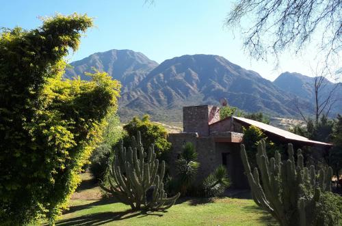 an old house with mountains in the background at Cabañas Altos del Velazco in La Rioja