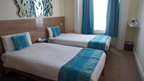 a hotel room with two beds and a window at Abbey Court Hotel - Hyde Park in London
