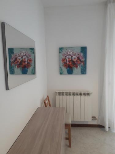 un comedor con una mesa y dos fotos de flores en Villa Susy en Desenzano del Garda