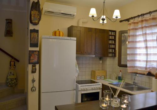 een keuken met een witte koelkast en een wastafel bij Harmony seaside apartments in Koropi