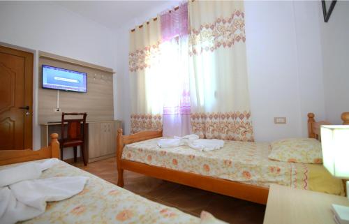 Cette chambre comprend 2 lits et une télévision. dans l'établissement My Home Guest House-Apartment, à Durrës