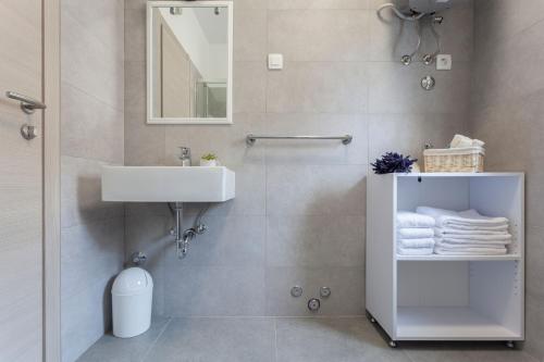 a white bathroom with a sink and a mirror at Atena Zaton 2 in Nin