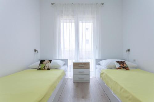 two beds in a room with white walls at Atena Zaton 2 in Nin