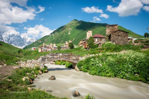 a bridge over a river next to a mountain at Guesthouse Lika in Ushguli