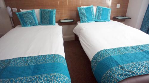 two beds in a hotel room with blue and white at Abbey Court Hotel - Hyde Park in London