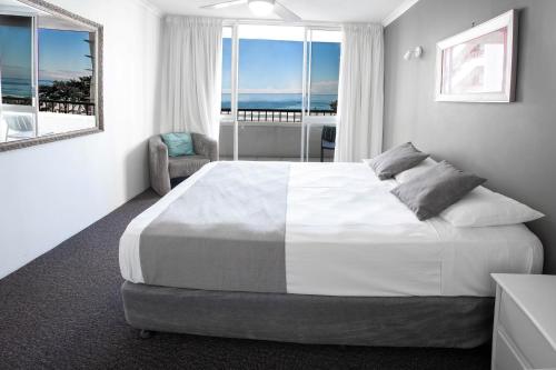 1 dormitorio con 1 cama grande y vistas al océano en View Pacific Apartments, en Gold Coast
