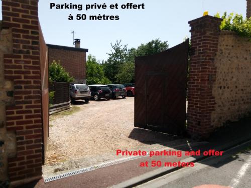 una puerta de madera en una entrada con coches aparcados en -La Batisse -Parking privé -Coeur historique - La Clef de Honfleur, en Honfleur