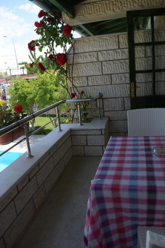 a patio with a table and a balcony with roses at Hotel HAL-TUR in Pamukkale