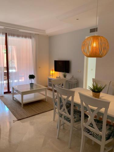 uma sala de estar com uma mesa e cadeiras e uma televisão em Beachside Apartment in Marbella em Marbella