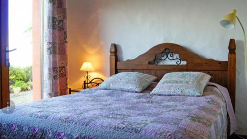 een slaapkamer met een bed met een paars dekbed en een raam bij Casa Primavera in Genovés