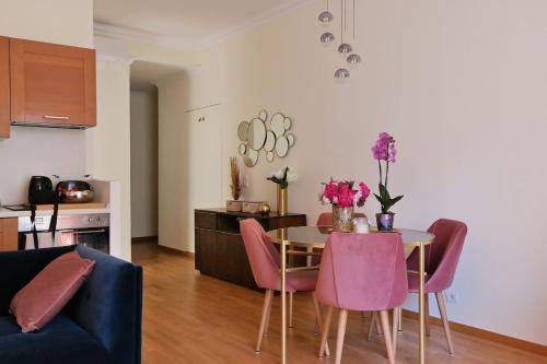 uma sala de estar com uma mesa com cadeiras cor-de-rosa em Nice Apartment Roses & Ivy, Rue du Congres em Nice