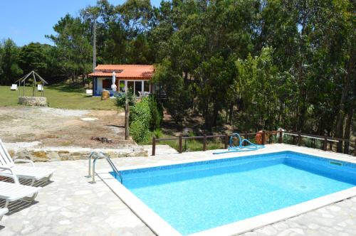 a swimming pool in a yard with a house at Quinta dos Mangues in São Martinho do Porto