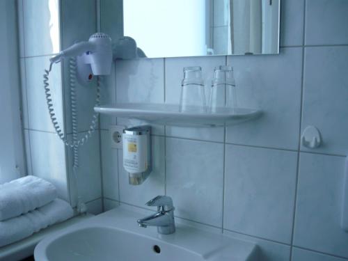 ein Bad mit einem Waschbecken und einem Spiegel in der Unterkunft Hotel Krone Lindow in Lindow