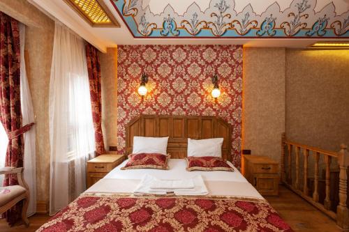 ein Schlafzimmer mit einem großen Bett mit einer rot gemusterten Wand in der Unterkunft Enderun by Otantik Suites in Istanbul