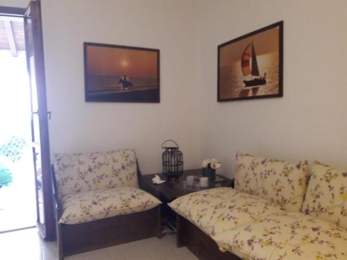 ein Wohnzimmer mit einem Sofa und einem Stuhl in der Unterkunft Splendida villetta Kal'e Moru in Marongiu
