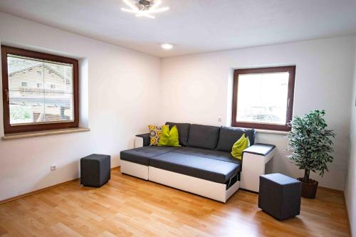 a living room with a couch and two windows at Ferienwohnung Eller 79 in Vals