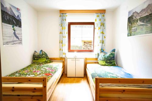 a bedroom with two beds and a window at Ferienwohnung Eller 79 in Vals