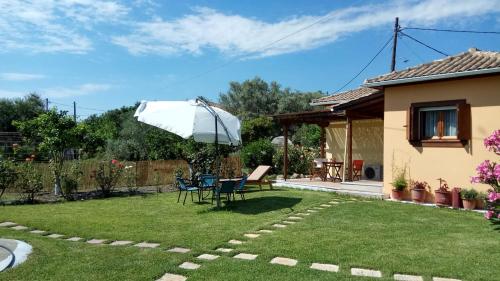 a garden with a table and chairs and an umbrella at Garden House Lefkada in Lygia