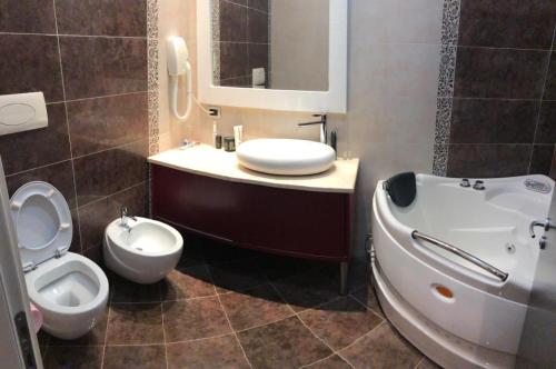 uma casa de banho com um WC, um bidé e um lavatório. em Grand Hotel Petrol em Fier
