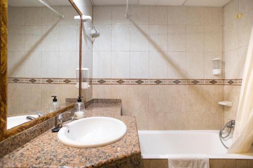 a bathroom with a sink and a bath tub at Hotel Villa Barbara in Can Picafort