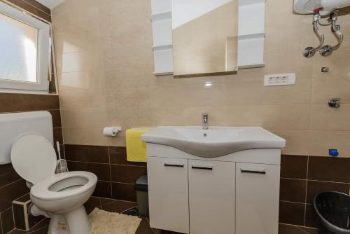 een badkamer met een toilet en een wastafel bij Apartmani Biočić in Kaštela