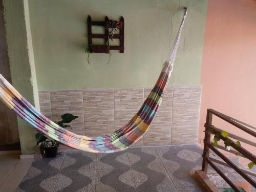 a hammock in a room with a cat sitting in it at Casa Larithur in Beberibe
