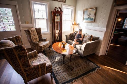 a woman sitting on a couch in a living room at Blackbeard's Lodge in Ocracoke