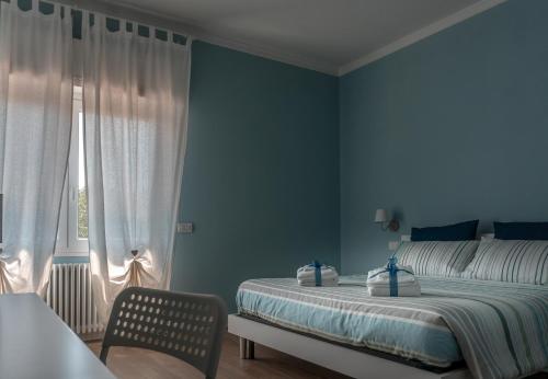 Dormitorio azul con cama y ventana en La Rosa Tra I Laghi B&B en Meina
