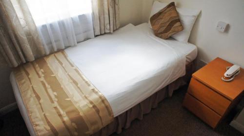 a bedroom with a large bed with a window at Abbey Court Hotel - Hyde Park in London